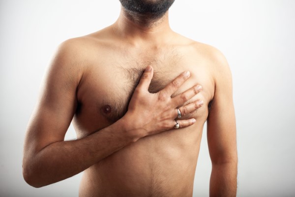 Ginecomastia; imagen de un hombre tocando su pecho tras someterse a un procedimiento de ginecomastia.